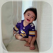 Raidyn joined the competition — help win amazing prizes! barefoot, candid, casual, child, curtain, cute, happy, indoor, infant, joyful, person, portrait, purple_jersey, sitting, small_child, smiling, sportswear, toddler, wall, young_child