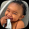 Messiah is registered to the contest to win money with this photo: baby, smiling, towel, wet_hair, curly_hair, chair, face, skin, hand, fingers, happy, cute, infant, closeup, expression, child, seat, background, texture, portrait