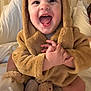 baby, child, smiling, happy, cute, costume, bear, hood, plush, soft, bed, blanket, pajamas, infant, indoors, portrait, sitting, hands, face, joy