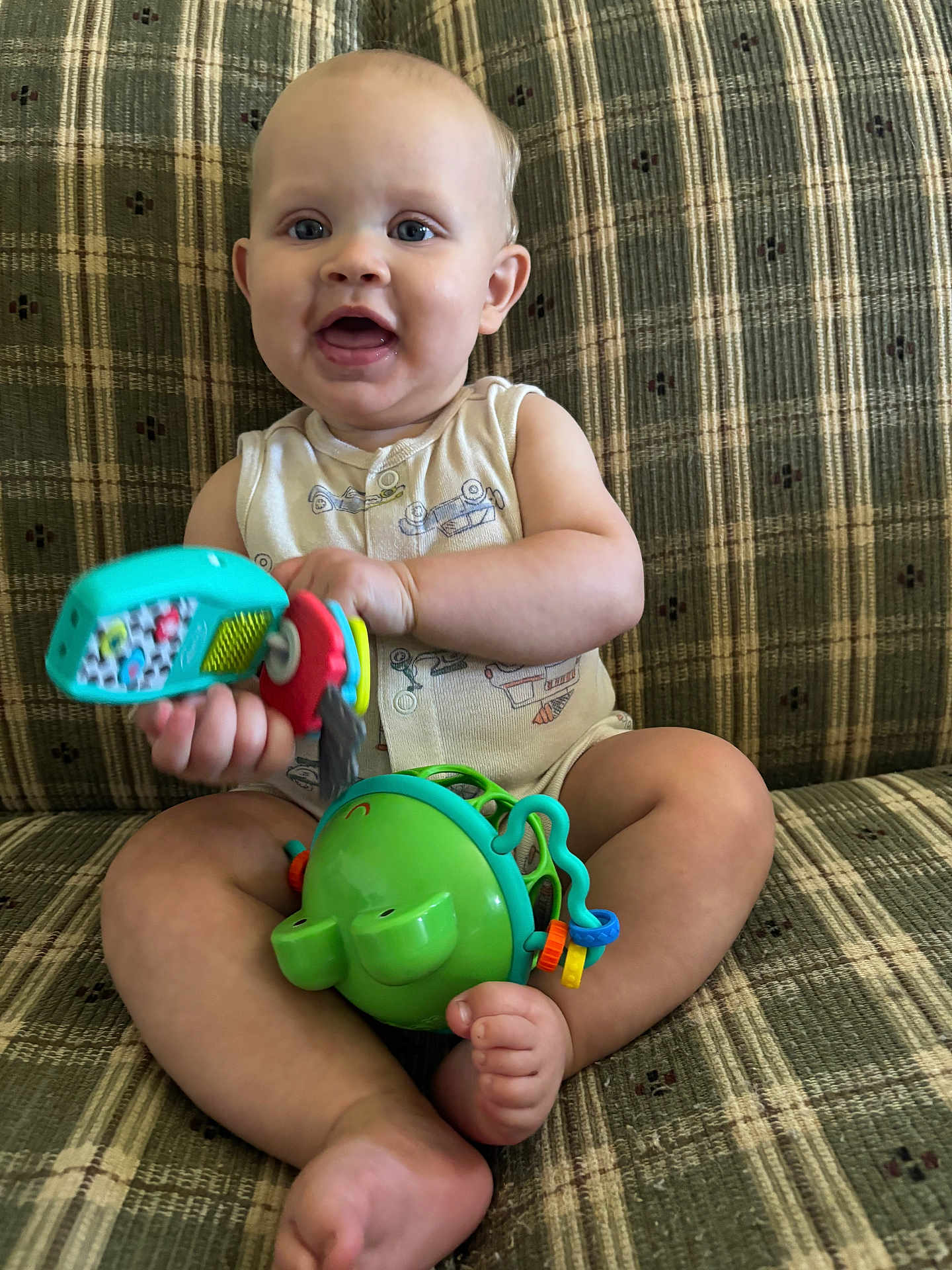 Maverick joined the competition — help win amazing prizes! baby, child, toy, couch, plaid, smile, happy, sitting, indoor, person, infant, clothing, foot, hand, face, play, colorful, cute, expression, furniture