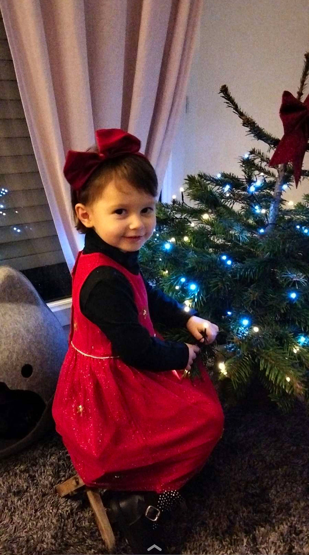 Louise a rejoint le concours — aidez-le/la à gagner de superbes lots ! christmas, christmas_decoration, christmas_ornament, christmas_tree, curtain, electric_blue, event, evergreen, fun, hair, happy, holiday, holiday_ornament, lighting, magenta, ornament, person, room, smile, toddler