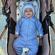 Ianis participe au concours pour gagner de l'argent avec cette photo : baby, child, stroller, onesie, blue_clothing, bear_pattern, cushion, pillow, outdoor, sidewalk, infant, cute, face, headwear, footwear, person, seated, blanket, soft_toy, portrait