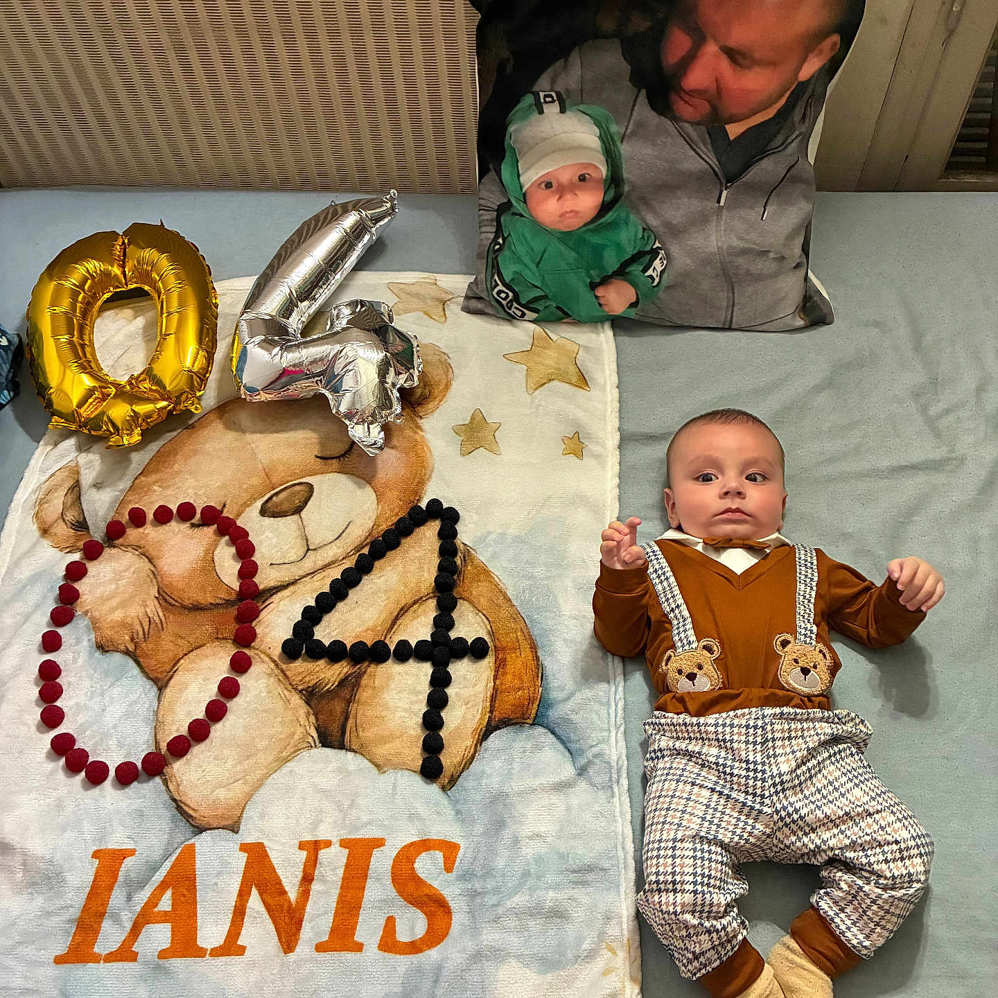 Ianis a rejoint le concours — aidez-le/la à gagner de superbes lots ! baby, balloons, bed, blanket, clothing, cute, face, gray, indoor, name, number, orange, person, pillow, plaid, pom_poms, portrait, socks, stars, teddy_bear