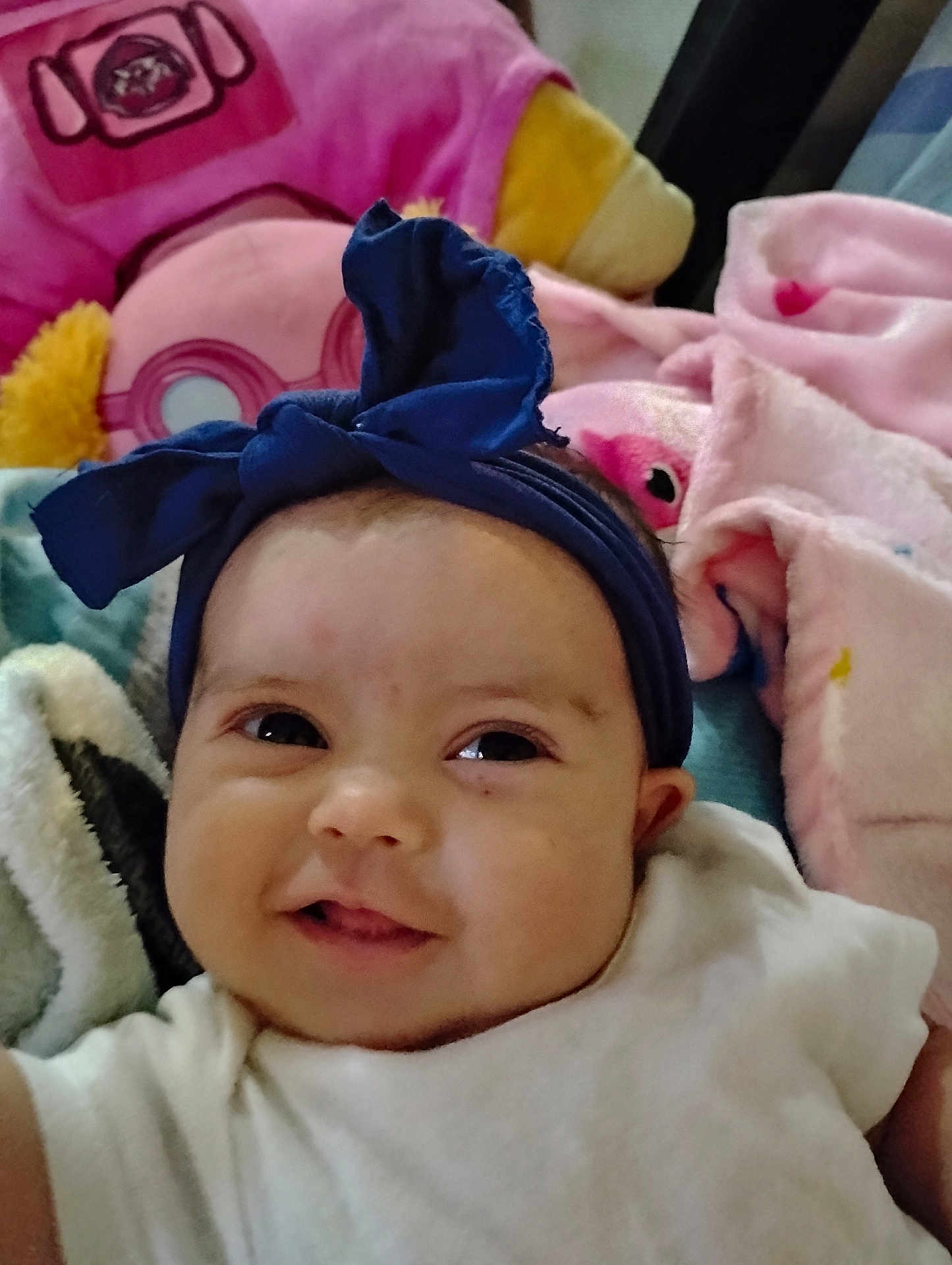Justice joined the competition — help win amazing prizes! baby, headband, smile, infant, blanket, soft_toys, pink, blue, white_clothing, face, cheeks, eyes, portrait, cute, indoors, child, happy, closeup, cozy, baby_bow