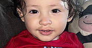 Ezra is registered to the contest to win money with this photo: baby, child, toddler, portrait, close_up, smiling, curly_hair, wet_hair, red_shirt, clothing, face, eyes, indoors, couch, stuffed_animal, toy, seated, happy, infant, photography