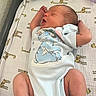 Jasper is registered to the contest to win money with this photo: newborn, baby, sleeping, onesie, cartoon_character, giraffe_print, blanket, infant, cute, stretching, soft_texture, diaper_wipes, pacifier, hand, foot, sleep, baby_clothing, indoors, resting, peaceful