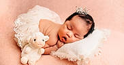 Harret Eloise joined the competition — help win amazing prizes! baby, sleeping, crown, plush_toy, lamb, pillow, lace_skirt, soft_texture, peach_background, infant, cute, resting, adorable, child, portrait, peaceful, newborn, soft_lighting, cozy, indoor