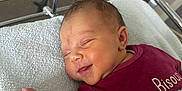 Lynaïa participe au concours pour gagner de l'argent avec cette photo : newborn, baby, sleeping, smiling, hospital, bassinet, blanket, clothing, infant, face, peaceful, cute, bed, soft, maroon, person, portrait, toddler, resting, cozy