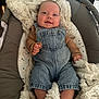 Lynaïa participe au concours pour gagner de l'argent avec cette photo : baby, infant, denim_overalls, blanket, cushion, smile, face, feet, hand, baby_seat, clothing, indoor, cute, child, soft_texture, cozy, portrait, person, relaxing, happy