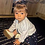 Lyana participe au concours pour gagner de l'argent avec cette photo : toddler, child, baby, indoor, carpet, black_and_white, striped, sitting, clothing, sweater, pony_tail, curly_hair, cute, young_child, footwear, hand, face, portrait, expression, home
