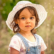 Éowyn a rejoint le concours — aidez-le/la à gagner de superbes lots ! bokeh, casual_clothing, child, curly_hair, cute, denim_overalls, expression, eyes, face, hat, innocence, nature, outdoor, person, portrait, soft_light, summer, sunhat, toddler, young