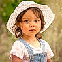 bokeh, casual_clothing, child, curly_hair, cute, denim_overalls, expression, eyes, face, hat, innocence, nature, outdoor, person, portrait, soft_light, summer, sunhat, toddler, young