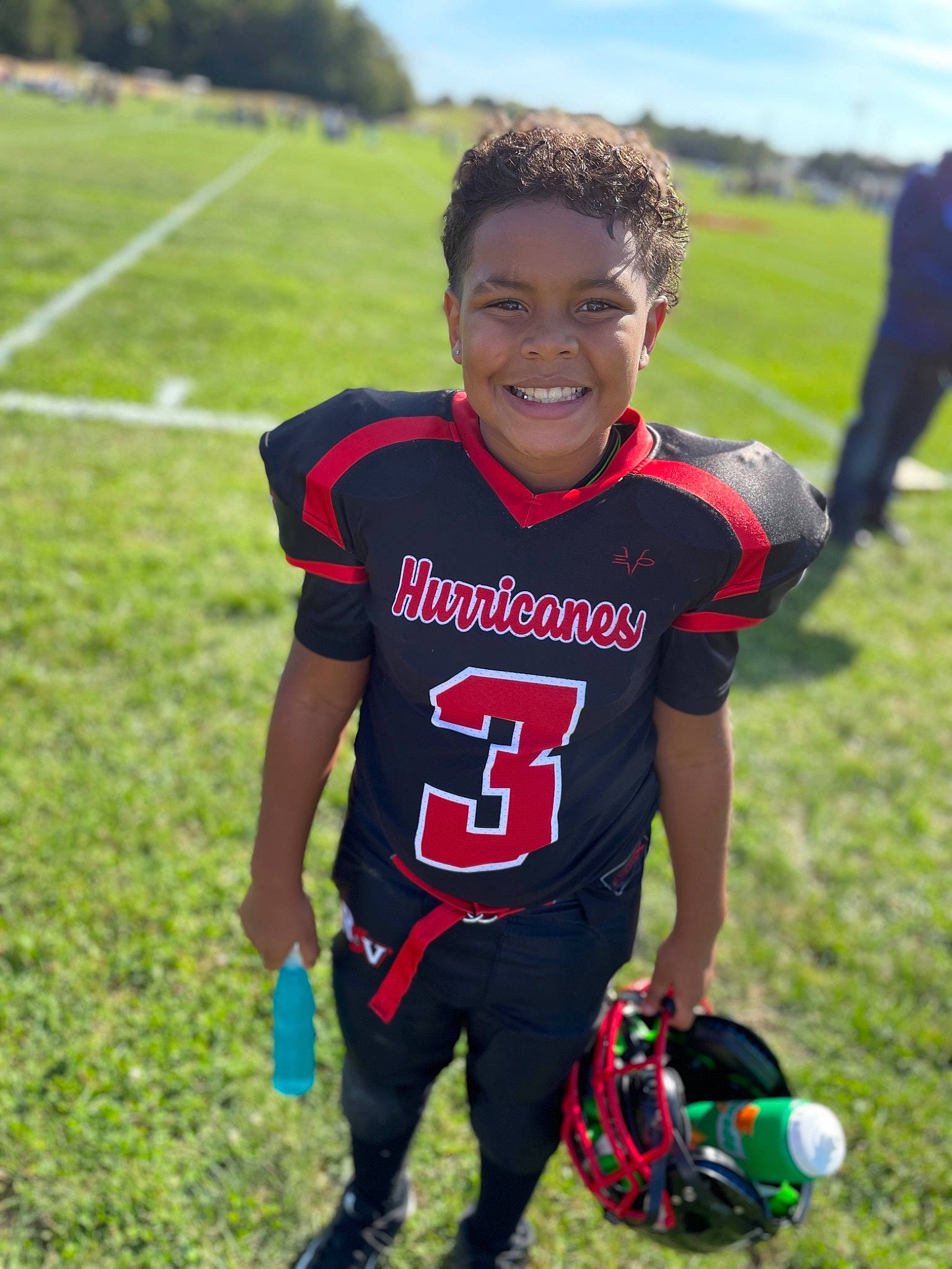 Omari joined the competition — help win amazing prizes! ball, ball_game, competition_event, face_mask, football, football_equipment, football_player, grass, happy, jersey, joy, person, player, recreation, shorts, sky, smile, sports, sports_equipment, sports_gear