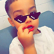 Joseph joined the competition — help win amazing prizes! child, boy, white_tshirt, indoor, pixelated_glasses, hand, face, short_hair, casual, sitting, young, cute, portrait, fingernail, expression, digital_overlay, funny, cool, playful, skin