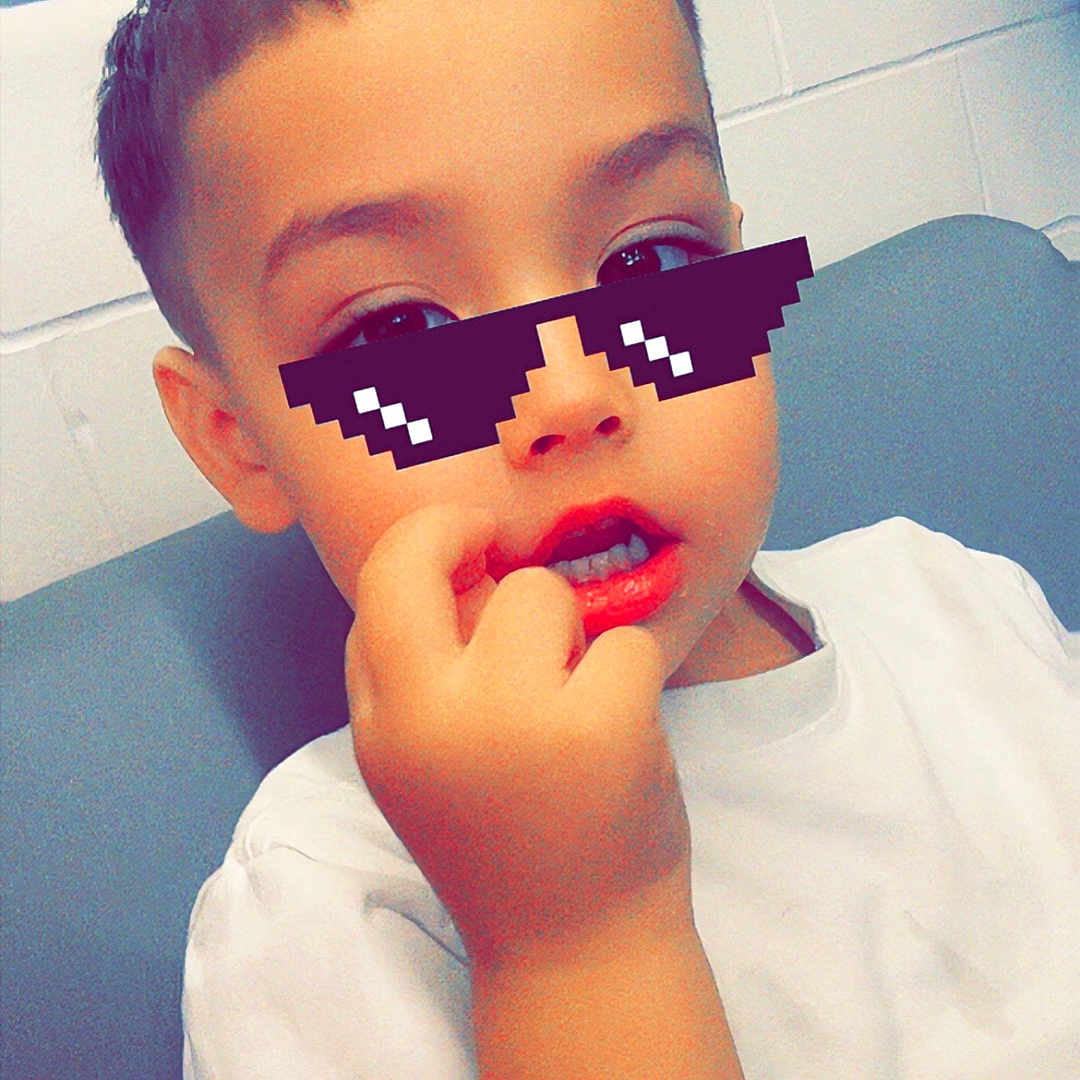 Joseph joined the competition — help win amazing prizes! child, boy, white_tshirt, indoor, pixelated_glasses, hand, face, short_hair, casual, sitting, young, cute, portrait, fingernail, expression, digital_overlay, funny, cool, playful, skin