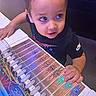 Joseph joined the competition — help win amazing prizes! toddler, child, electronics, wires, circuit_board, blue_light, table, curious, technology, person, short_hair, indoor, clothing, nike, hand, device, exploration, gadget, closeup, young