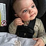 baby, child, car_seat, blue_eyes, blanket, pacifier, clothing, infant, seatbelt, closeup, cute, face, hand, indoor, portrait, safety, infancy, expression, person, toddler