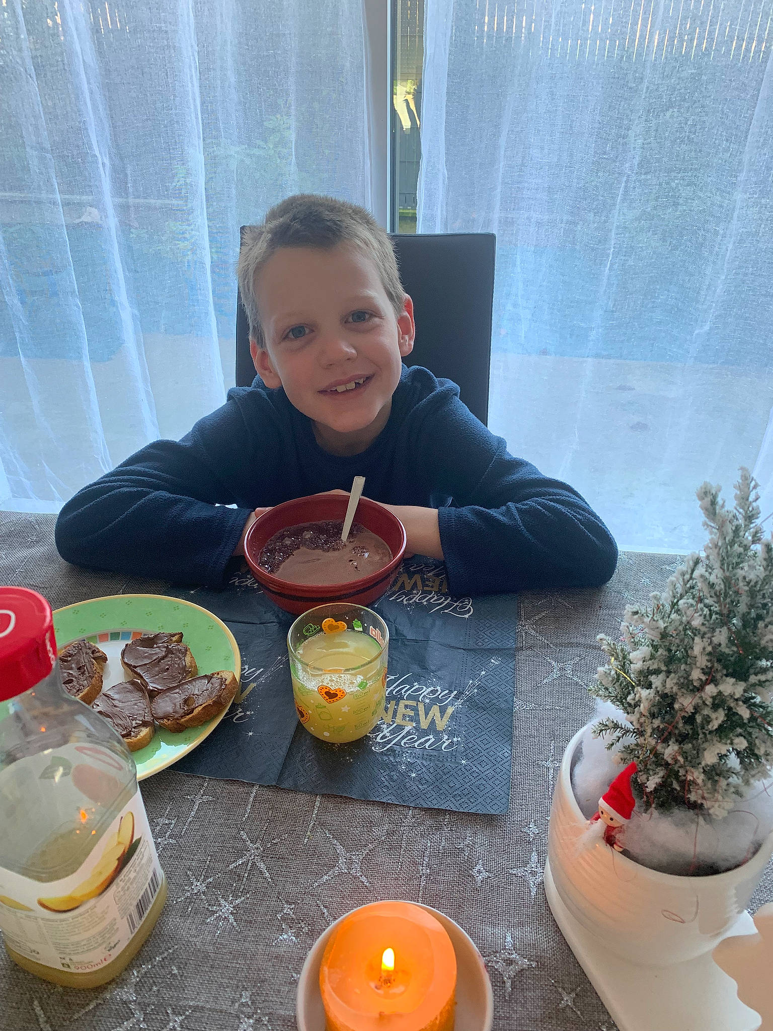 Luca participe au concours pour gagner de l'argent avec cette photo : bottle, candle, chair, child, comfort_food, cooking, cup, curtain, drinkware, flowerpot, herb, houseplant, joy, orange, person, plant, plate, serveware, smile, table