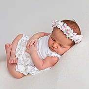 Leana a rejoint le concours — aidez-le/la à gagner de superbes lots ! baby, sleeping, infant, flower_headband, white_clothing, lace, peaceful, soft_texture, cute, newborn, portrait, child, resting, indoors, skin, head, hands, feet, closeup, adorable