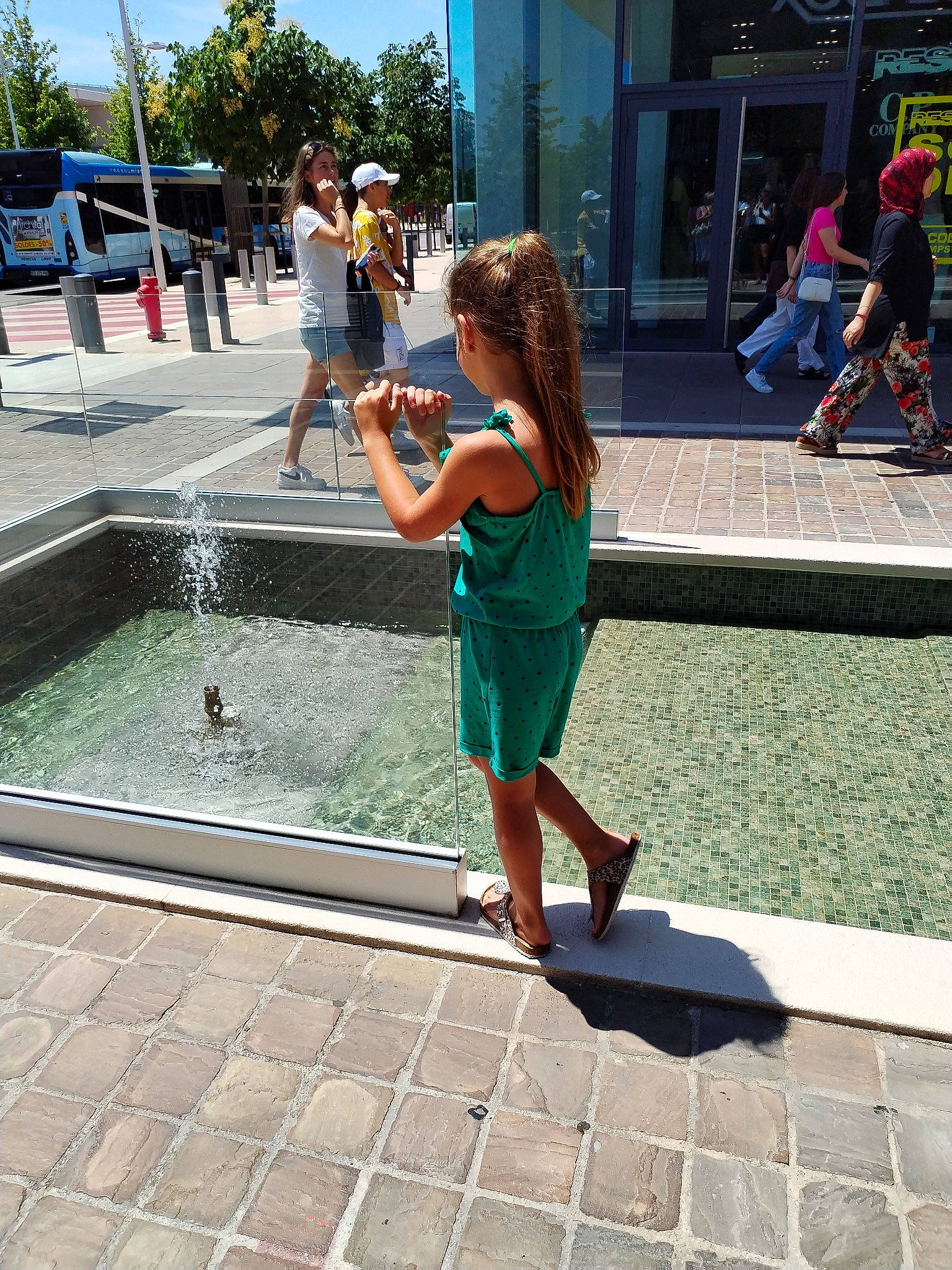 Tess participe au concours pour gagner de l'argent avec cette photo : barefoot, city, clothing, electric_blue, foot, fountain, fun, grass, headwear, human_leg, leg, leisure, person, recreation, road, road_surface, sidewalk, standing, thigh, tree