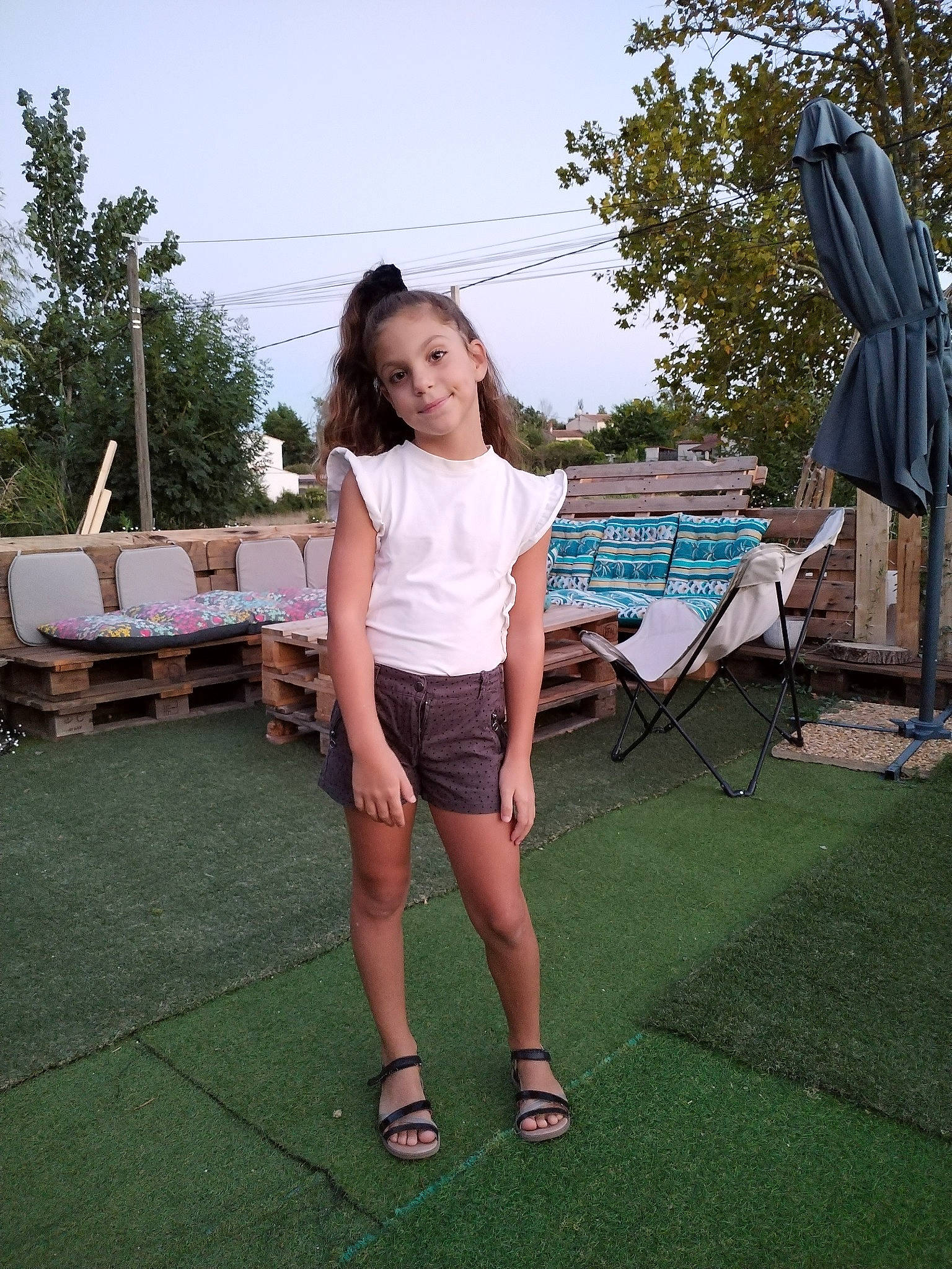 Tess participe au concours pour gagner de l'argent avec cette photo : event, fun, grass, happy, human_leg, joy, knee, leg, leisure, magenta, person, recreation, sandal, shorts, sitting, sky, smile, summer, t_shirt, thigh