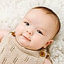 Bryson is registered to the contest to win money with this photo: baby, infant, face, smile, knitted_clothing, beige, wooden_buttons, soft_texture, blanket, cute, child, portrait, close_up, lying_down, skin, eyelashes, head, cheeks, happy, newborn