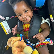 Khelyana participe au concours pour gagner de l'argent avec cette photo : baby, bead_chain, car_seat, child, child_safety, clothing, colorful, cute, hair_puffs, happy, indoors, infant, person, plush_toy, portrait, safety_harness, seatbelt, smiling, toddler, toy