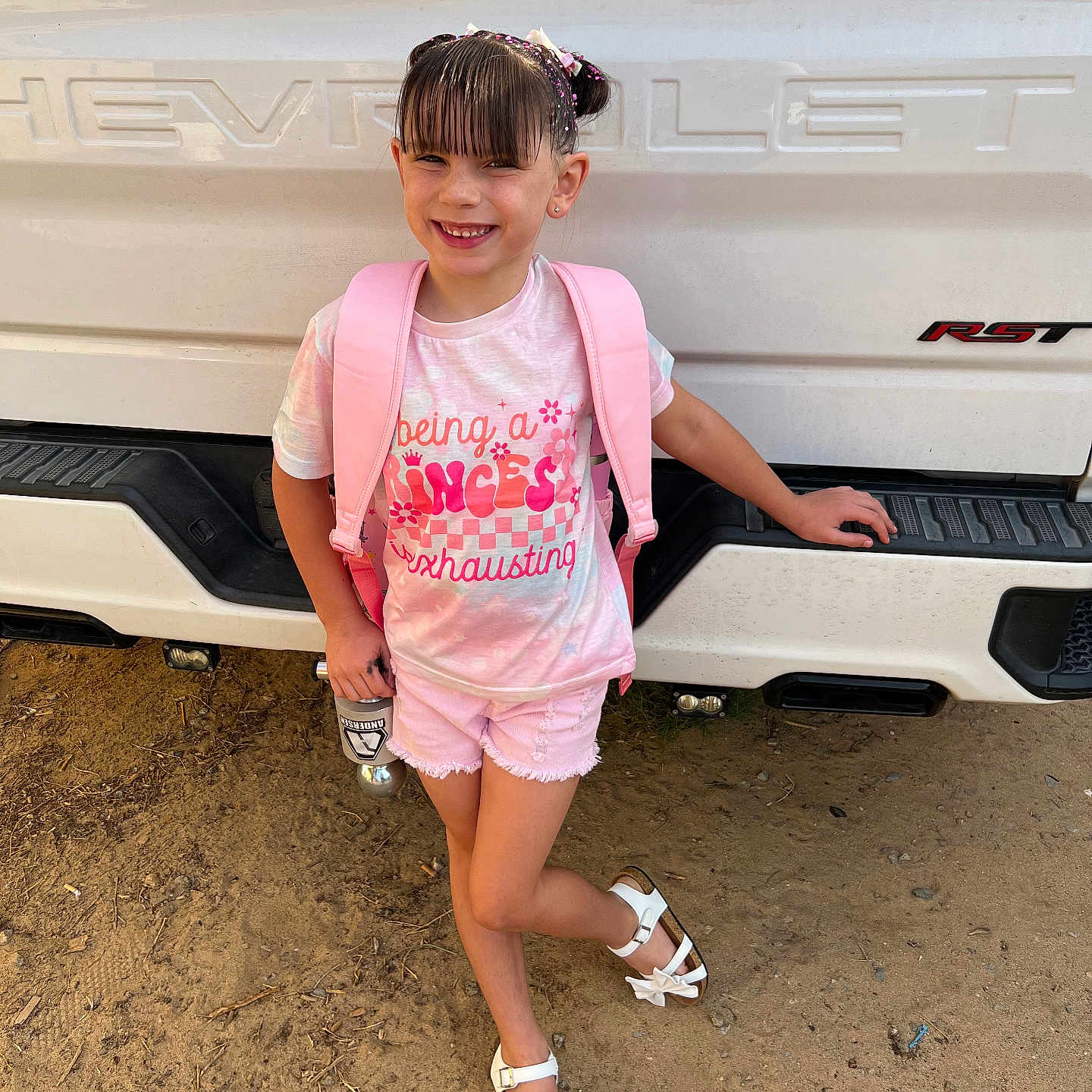 Parris is registered to the contest to win money with this photo: bag, beachwear, bumper, child, clothing, face, female, footwear, girl, head, highheel, person, photography, portrait, sandal, shoe, shorts, sleeve, transportation, vehicle