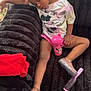 child, girl, sleeping, couch, plush, minnie_mouse, shirt, pink, sippy_cup, hairbrush, red_clothing, casual, indoor, relaxed, shoes, floor, hair_bow, comfort, nap, furniture