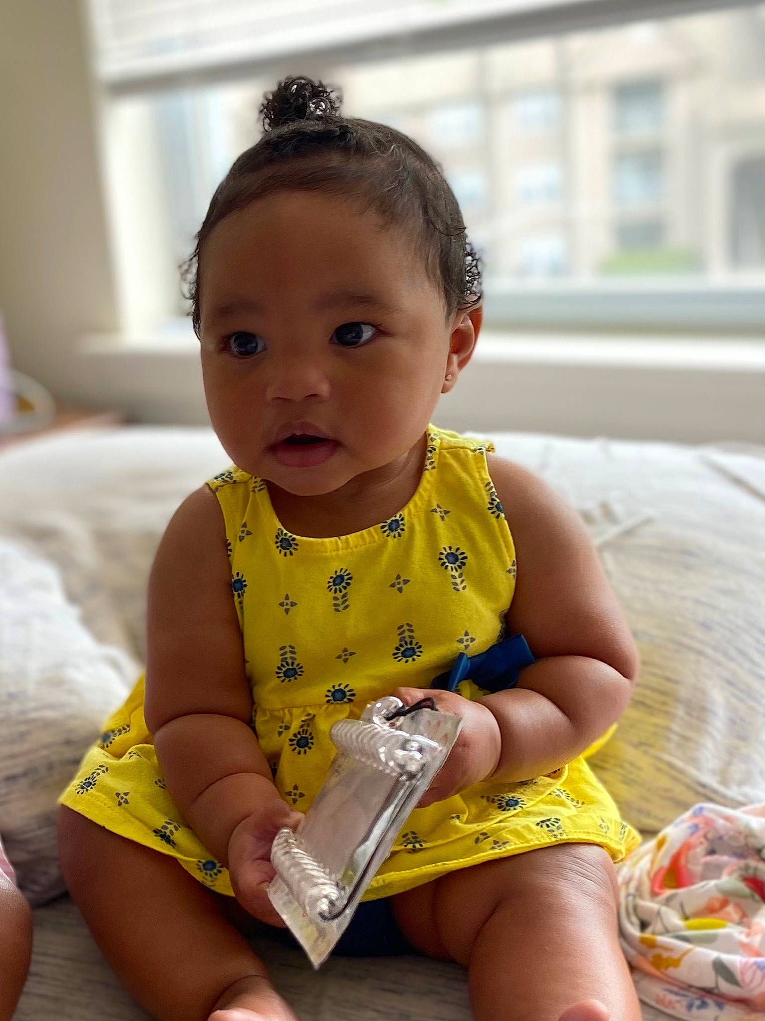 Noelle is registered to the contest to win money with this photo: baby, baby_products, baby_toddler_clothing, barefoot, child, fun, hairstyle, happy, head, human_leg, knee, neck, pattern, person, sitting, skin, sleeve, sleeveless_shirt, thigh, toddler