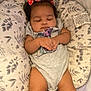 Aurora is registered to the contest to win money with this photo: baby, infant, sleeping, bows, hair_accessory, pillow, blanket, onesie, hands, legs, cozy, indoor, child, cute, peaceful, soft_texture, patterned, resting, adorable, portrait