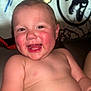 baby, child, smiling, happy, rosy_cheeks, toothy_grin, bare_chest, dinosaur_background, indoor, cute, infant, portrait, young_child, playful, close_up, cheerful, skin, face, sitting, joyful