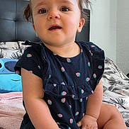 Lana a rejoint le concours — aidez-le/la à gagner de superbes lots ! toddler, child, baby, face, hands, legs, dress, pigtails, bed, bedding, pattern, strawberry_print, curious, indoor, person, skin, hair, expression, seated, furniture