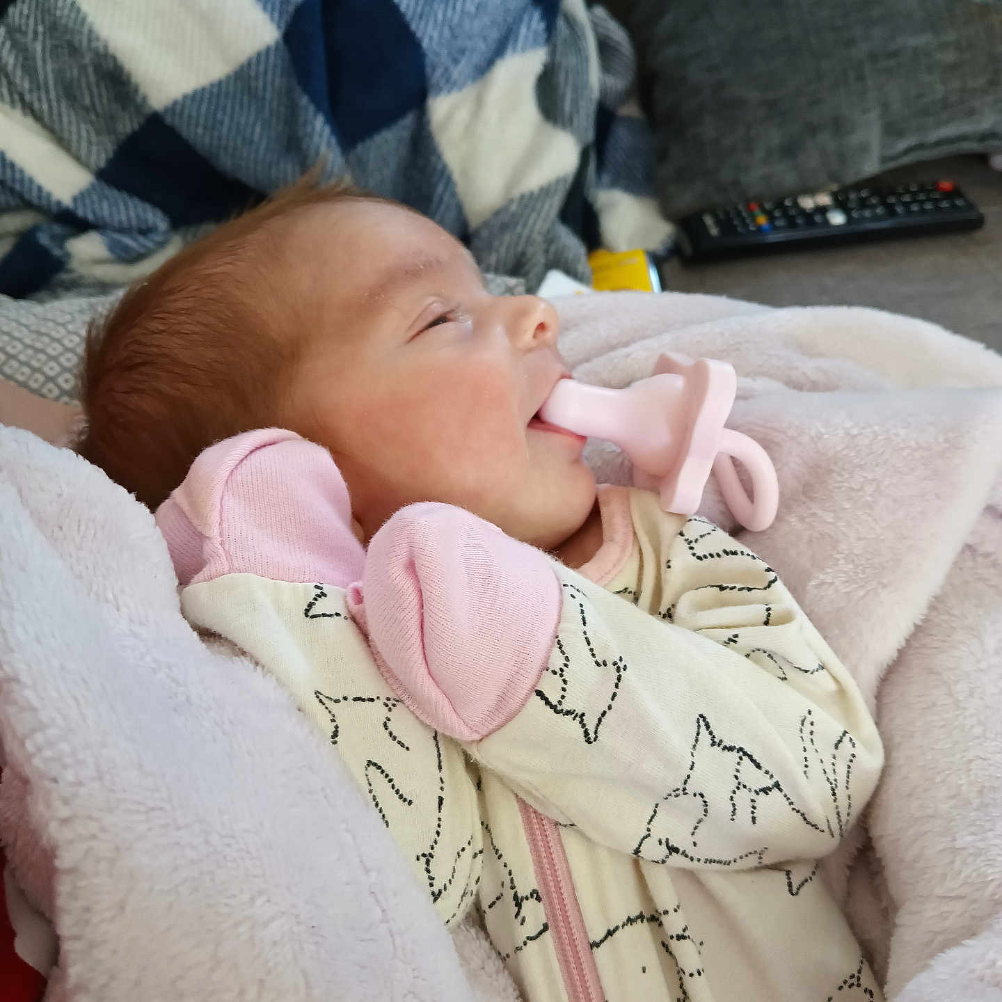 Maddox is registered to the contest to win money with this photo: baby, blanket, bodypart, clothing, couch, cushion, electronics, face, finger, furniture, hand, head, homedecor, knitwear, newborn, person, photography, portrait, remotecontrol, sweater