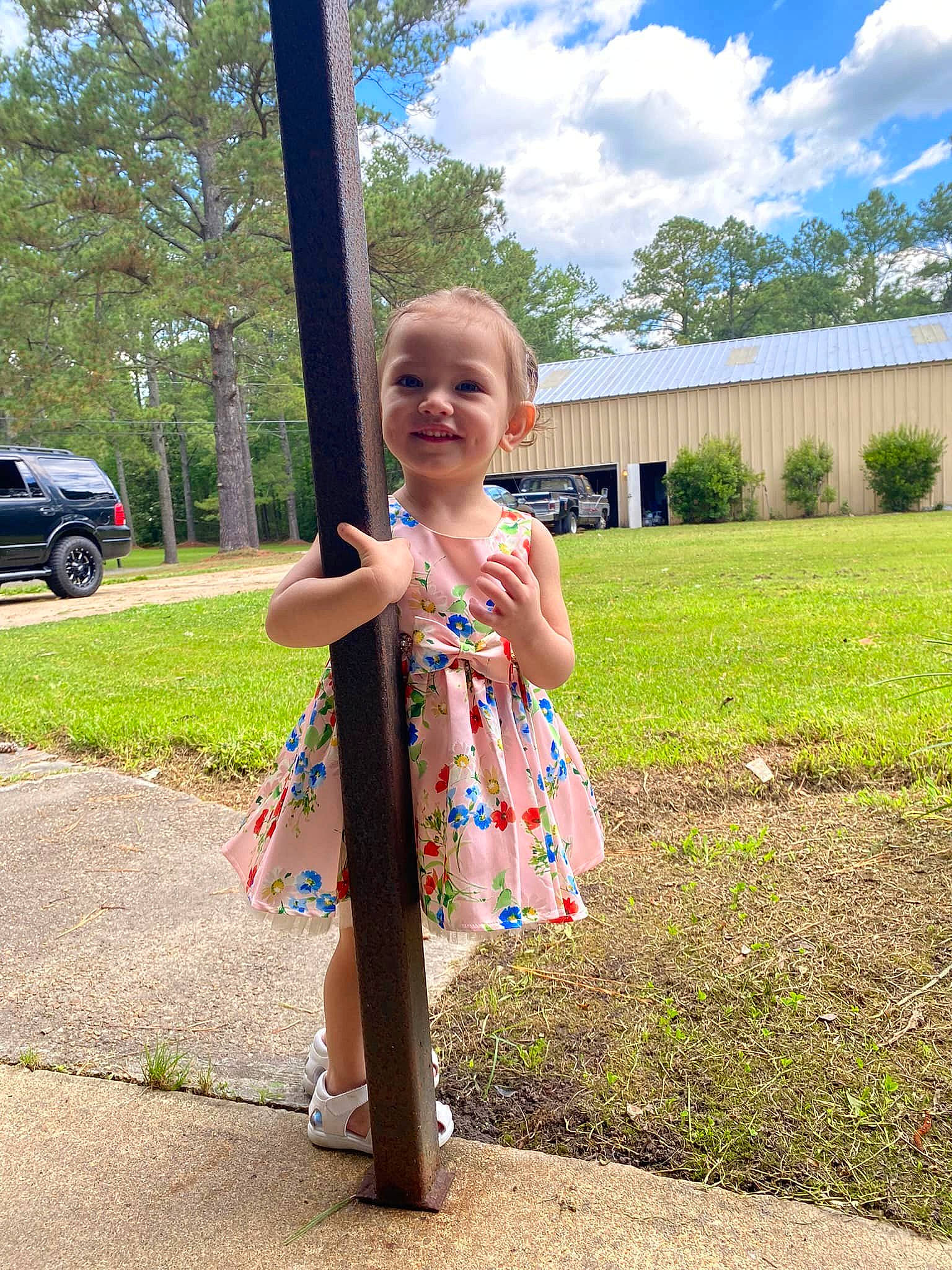 Olivia is registered to the contest to win money with this photo: asphalt, cloud, dress, electric_blue, fun, grass, happy, joy, leaf, leisure, people_in_nature, person, plant, recreation, sky, smile, tire, toddler, tree, vehicle