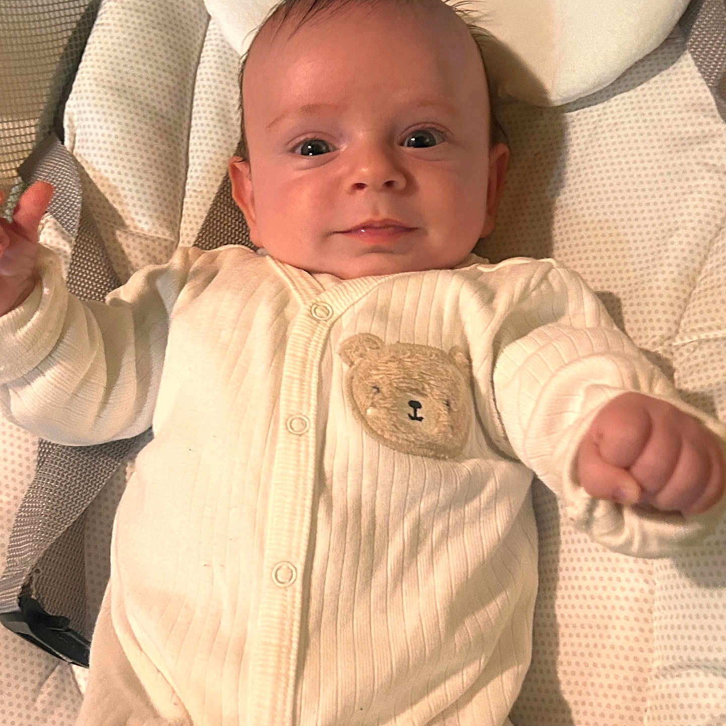 Siar is registered to the contest to win money with this photo: baby, baby_seat, child, comfort, cushion, cute, face, hand, happy, indoor, infant, newborn, onesie, portrait, resting, smiling, soft_lighting, teddy_bear_patch, white_clothing, young