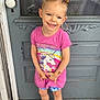 casual, child, door, doorstep, girl, hair_buns, happy, outdoor, patterned_shorts, person, pink, rug, shoes, shorts, smiling, standing, tattoos, tshirt, unicorn, wood