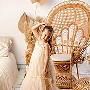 Zoé a rejoint le concours — aidez-le/la à gagner de superbes lots ! barefoot, boho_style, child, cute, decor, dress, fashion, floor, girl, happy, home, interior, natural_light, plant, portrait, pose, rattan_chair, smile, woven_rug, young