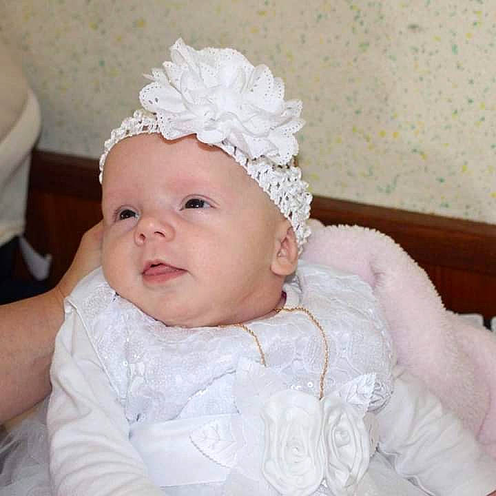 Maëlis a rejoint le concours — aidez-le/la à gagner de superbes lots ! baby, bonnet, cap, child, clothing, dress, fashion_accessory, fur, hair_accessory, head, headband, headgear, headpiece, lace, person, smile, toddler, white