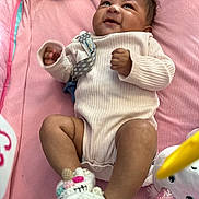 Delani joined the competition — help win amazing prizes! baby, infant, smiling, lying_down, pink_blanket, onesie, unicorn_slippers, plush_toy, soft_toys, indoors, cute, child, happy, cozy, small_hands, small_feet, looking_up, infant_clothing, baby_accessories, play_area