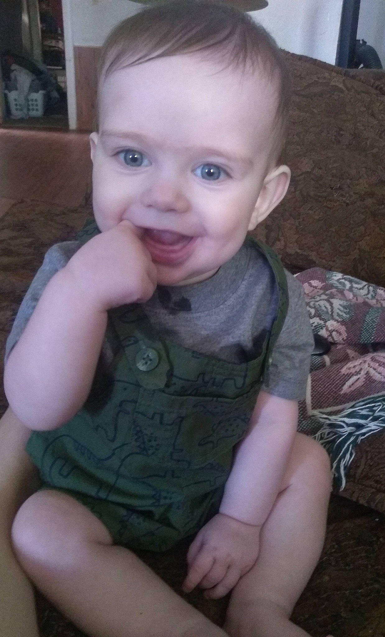 David is registered to the contest to win money with this photo: arm, baby, cheek, child, chin, eye, face, finger, forehead, hand, head, iris, lip, mouth, nose, person, sitting, skin, smile, thumb