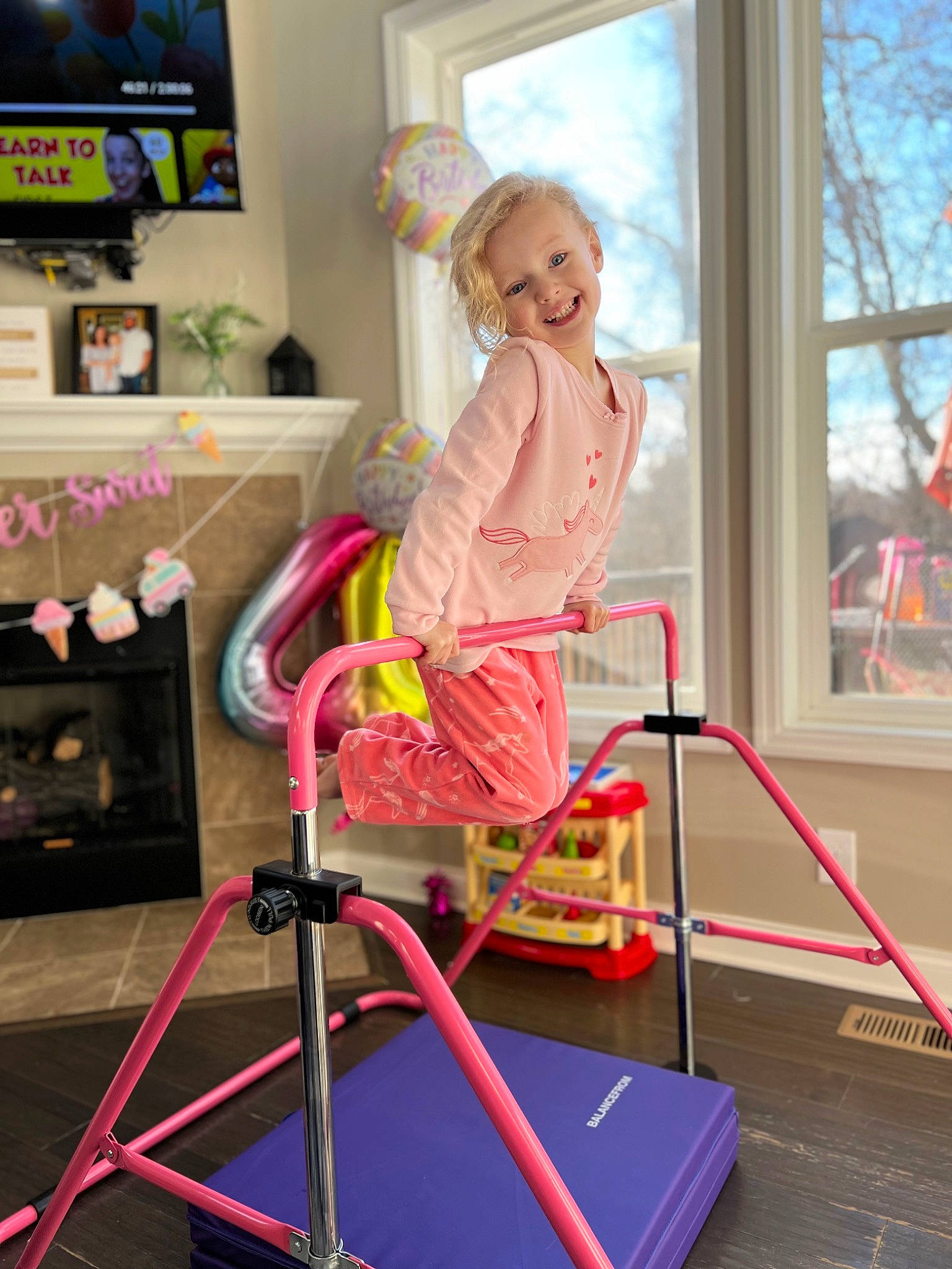 Kennedy joined the competition — help win amazing prizes! balance, blurred, chair, child, cleanliness, comfort, floor, flooring, joy, knee, leisure, magenta, person, picture_frame, pink, shelf, sitting, smile, stool, television