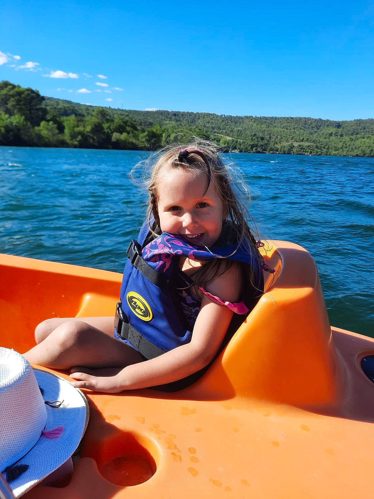 Taïs participe au concours pour gagner de l'argent avec cette photo : boat, boats_and_boating_equipment_and_supplies, cloud, comfort, fun, joy, lake, leisure, lifejacket, outdoor_recreation, person, personal_protective_equipment, recreation, sky, summer, toddler, travel, tree, vehicle, water