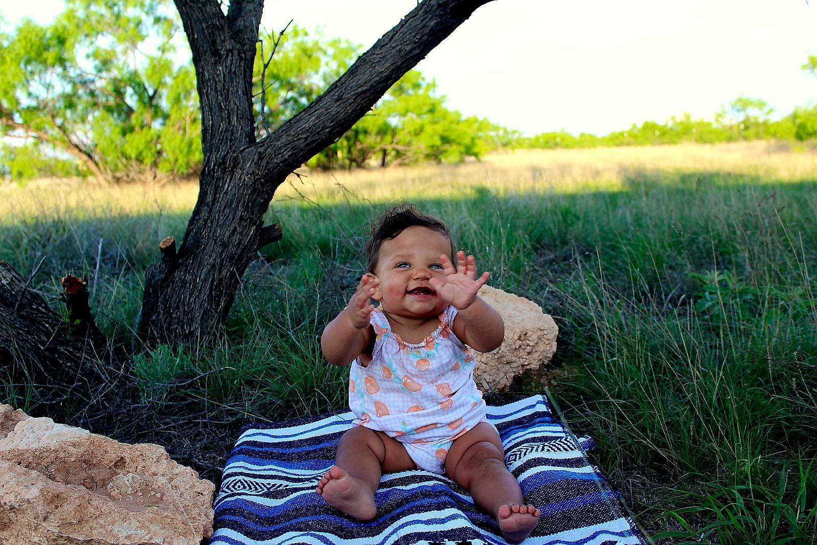Casey joined the competition — help win amazing prizes! baby, baby_toddler_clothing, eye, fun, grass, grass_family, grassland, happy, landscape, leaf, leisure, people_in_nature, person, plant, shorts, sitting, sky, smile, t_shirt, toddler