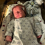 Isaac participe au concours pour gagner de l'argent avec cette photo : newborn, baby, sleeping, crib, hospital, onesie, hat, plush_toy, seal, blanket, infant, cute, cozy, resting, soft_lighting, peaceful, child, indoors, bed, pajamas