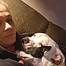 Whiteboy is registered to the contest to win money with this photo: person, dog, couch, indoor, closeup, face, white_dog, black_and_white_dog, snuggling, casual_clothing, relaxing, pet, companion, bonding, home, comfort, portrait, animal, furry_friend, resting