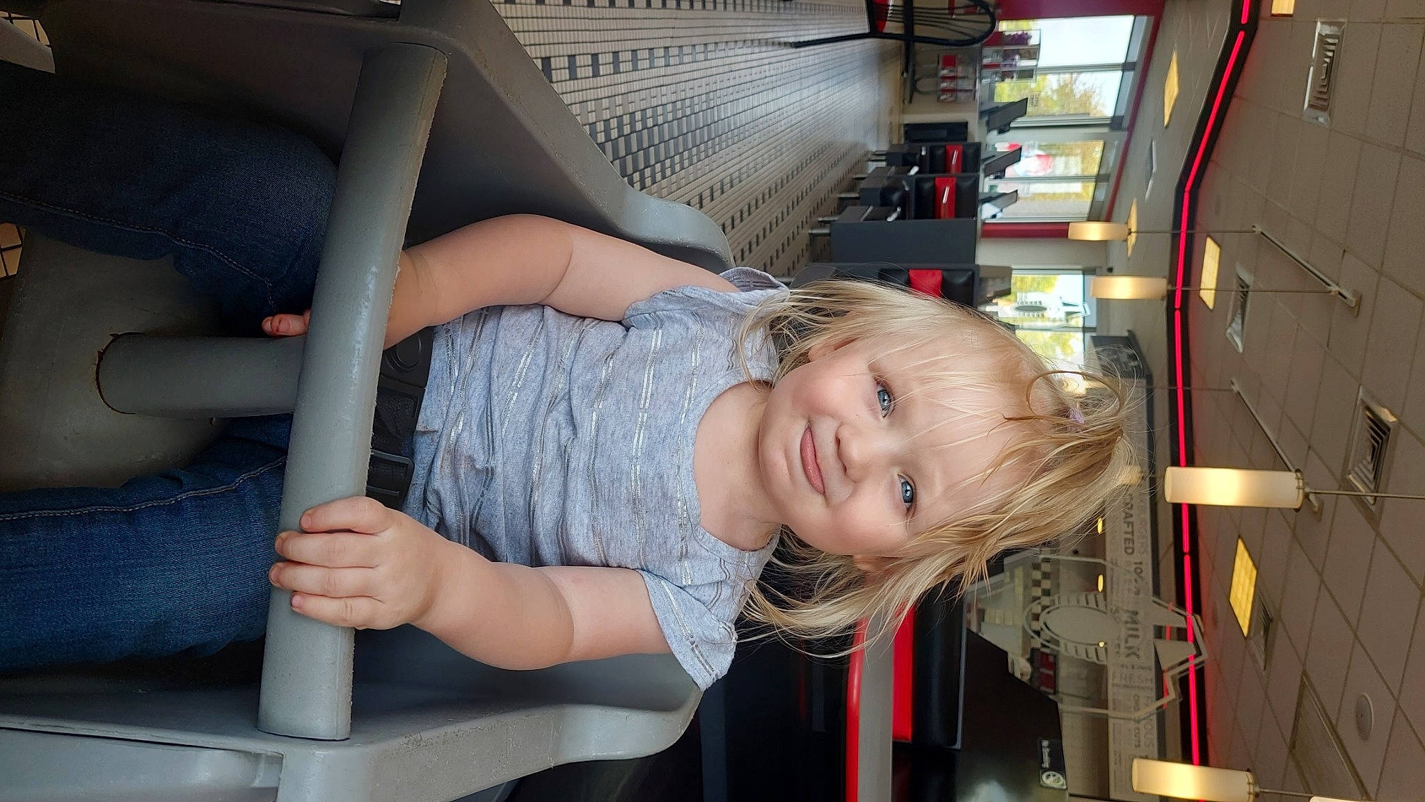 Ariel is registered to the contest to win money with this photo: blond, brown_hair, child, comfort, fun, human_leg, joy, lap, leg, leisure, long_hair, machine, motor_vehicle, person, public_transport, room, sitting, smile, thigh, toddler