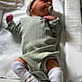 newborn, baby, pacifier, hat, socks, green_outfit, sleeping, changing_pad, star_pattern, infant, child, bedroom, blanket, soft_lighting, indoors, cute, resting, peaceful, baby_clothes, toddler