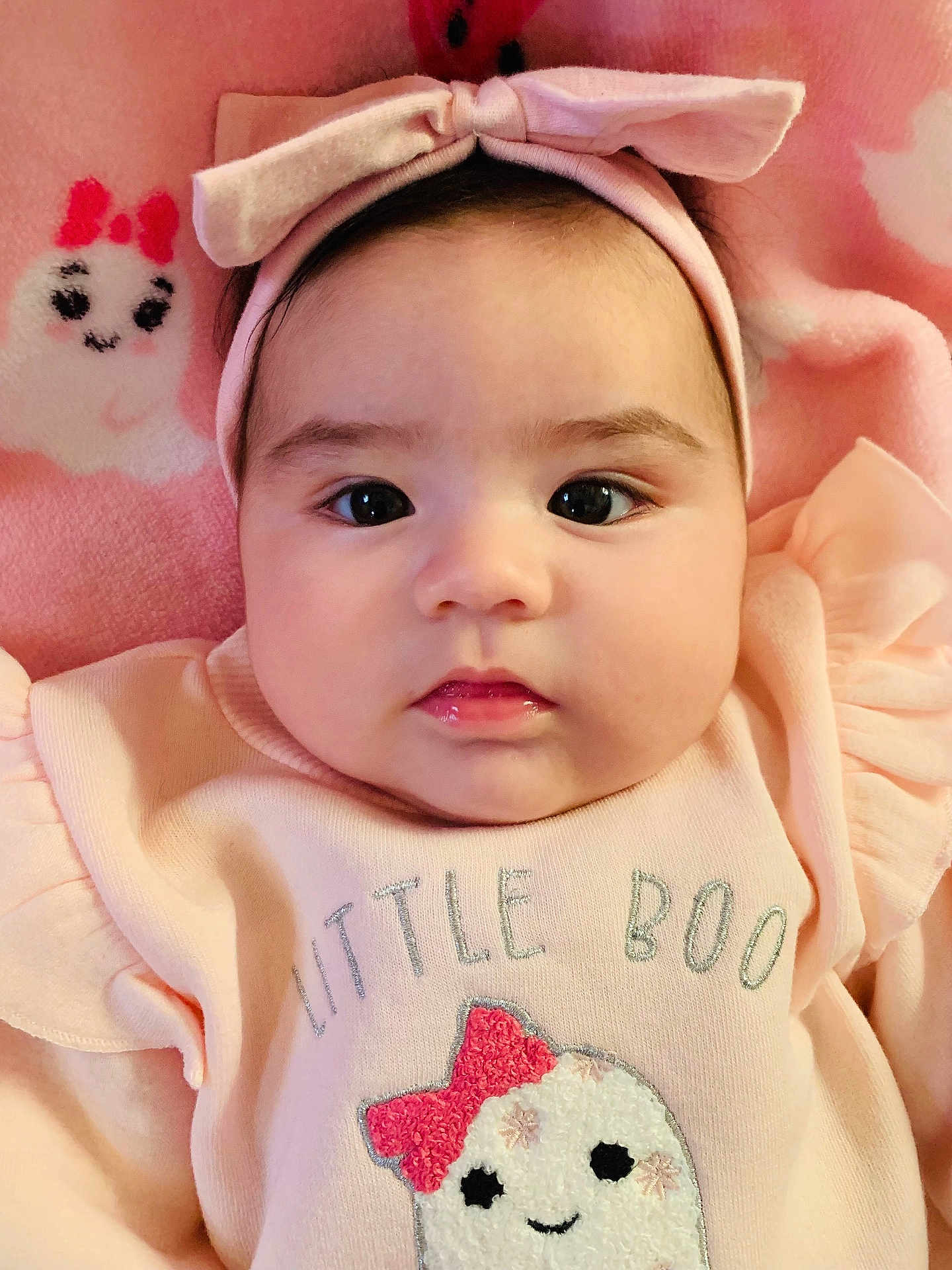 Nathalia joined the competition — help win amazing prizes! baby, infant, headband, bow, pink_clothing, cute, face, portrait, soft_blanket, expressionless, baby_girl, closeup, lying_down, indoors, child, adorable, small_person, baby_outfit, text_on_clothing, pink_background