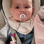 Athénaïs a rejoint le concours — aidez-le/la à gagner de superbes lots ! baby, baby_carrier, bib, child, closeup, clothing, cute, denim, face, holding, indoor, infant, pacifier, person, pink, seatbelt, smiling, soft_toy, toy, white